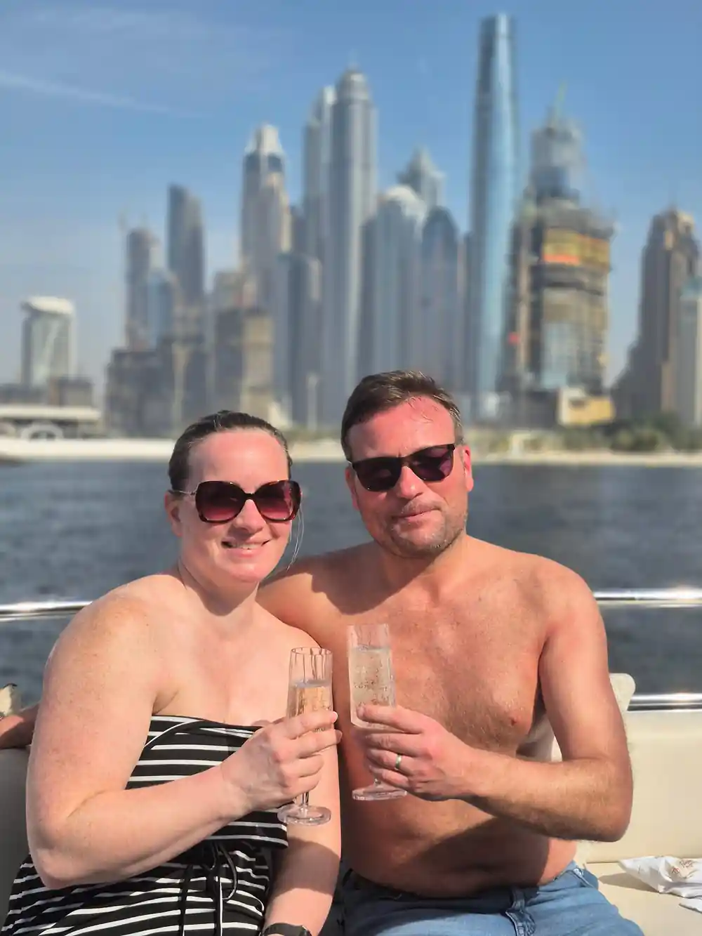 A couple toasting with glasses on the swim deck