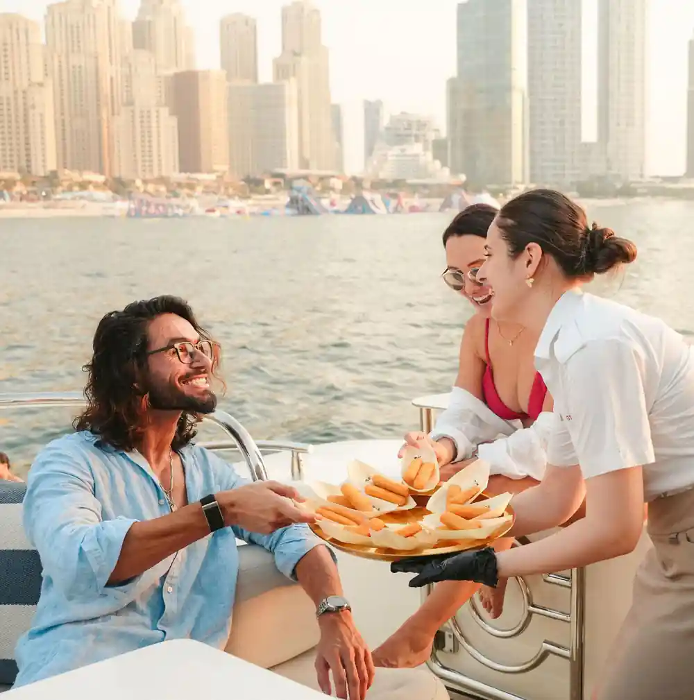 Crew serving a platter to guests on the aft deck
