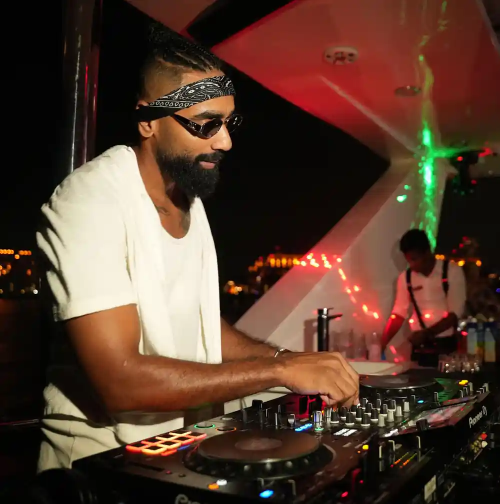 The DJ working the decks under coloured light