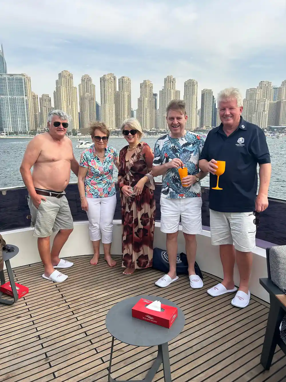 A group of guests with drinks posing on the aft deck