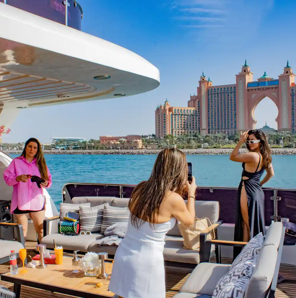Guests photographing each other on deck with Atlantis behind