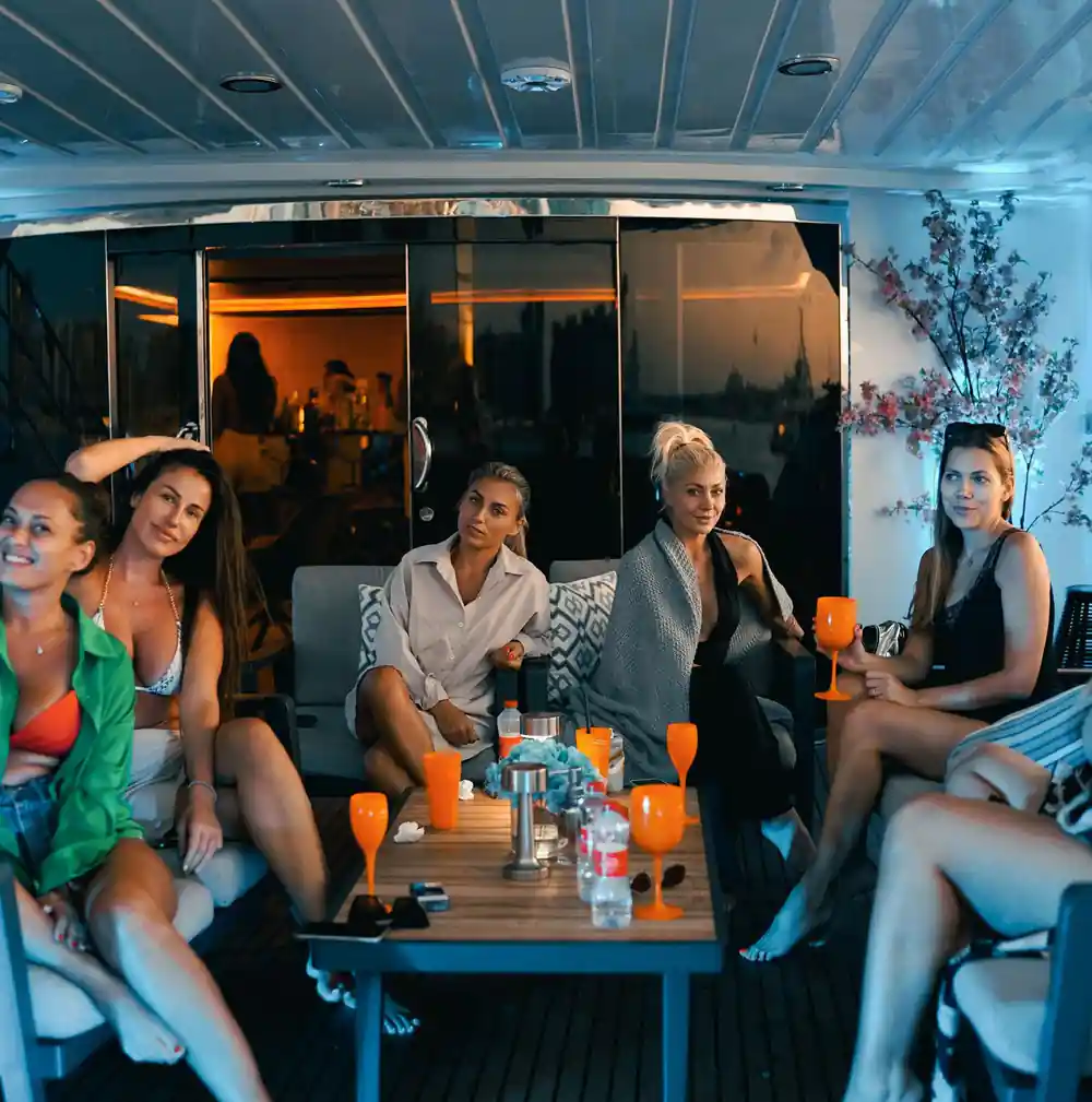 Guests seated together in the lounge with drinks at night