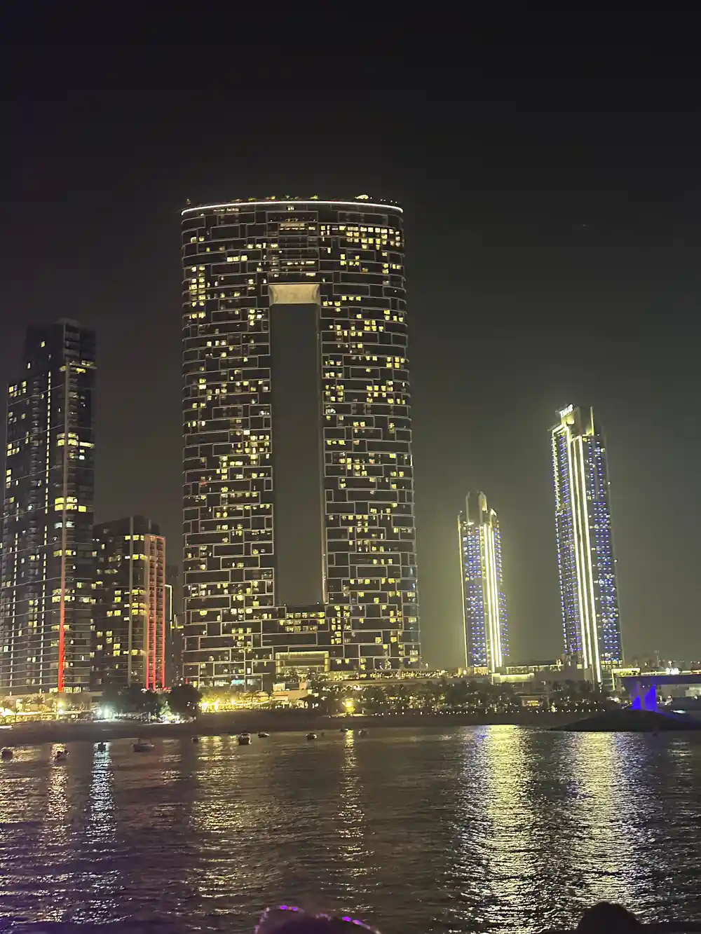 Illuminated towers reflected in the water at night