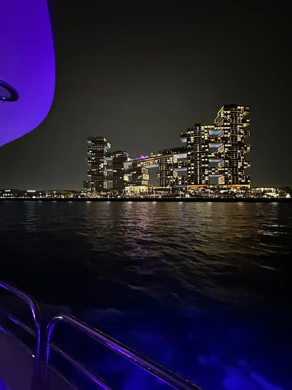 The lit Royal Atlantis tower across dark water