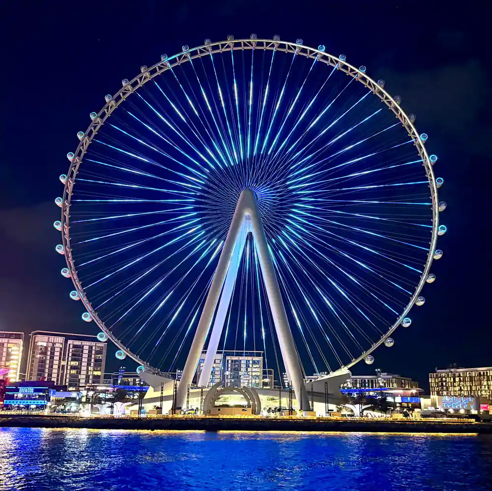 The observation wheel lit blue against the night sky