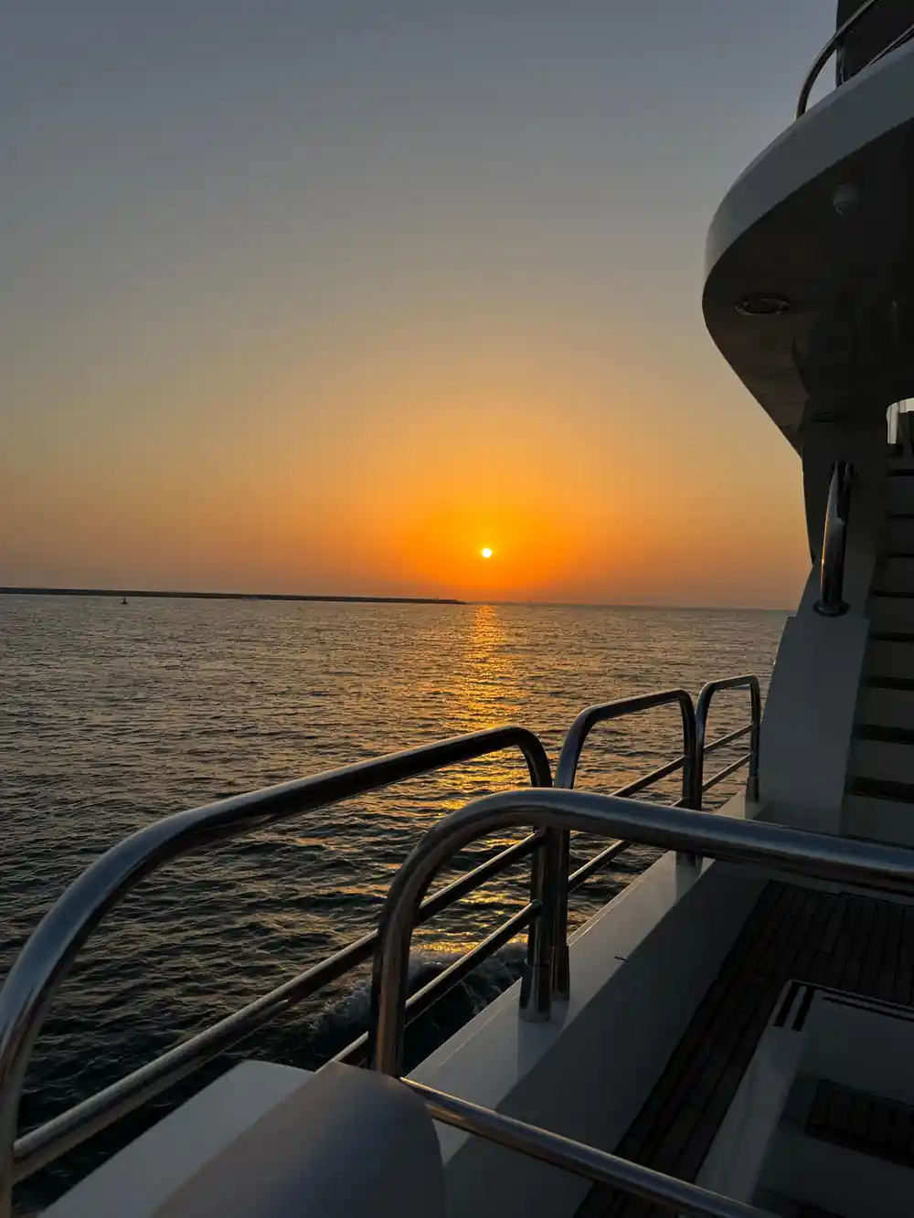 The sun low over the Gulf from the yacht's rail