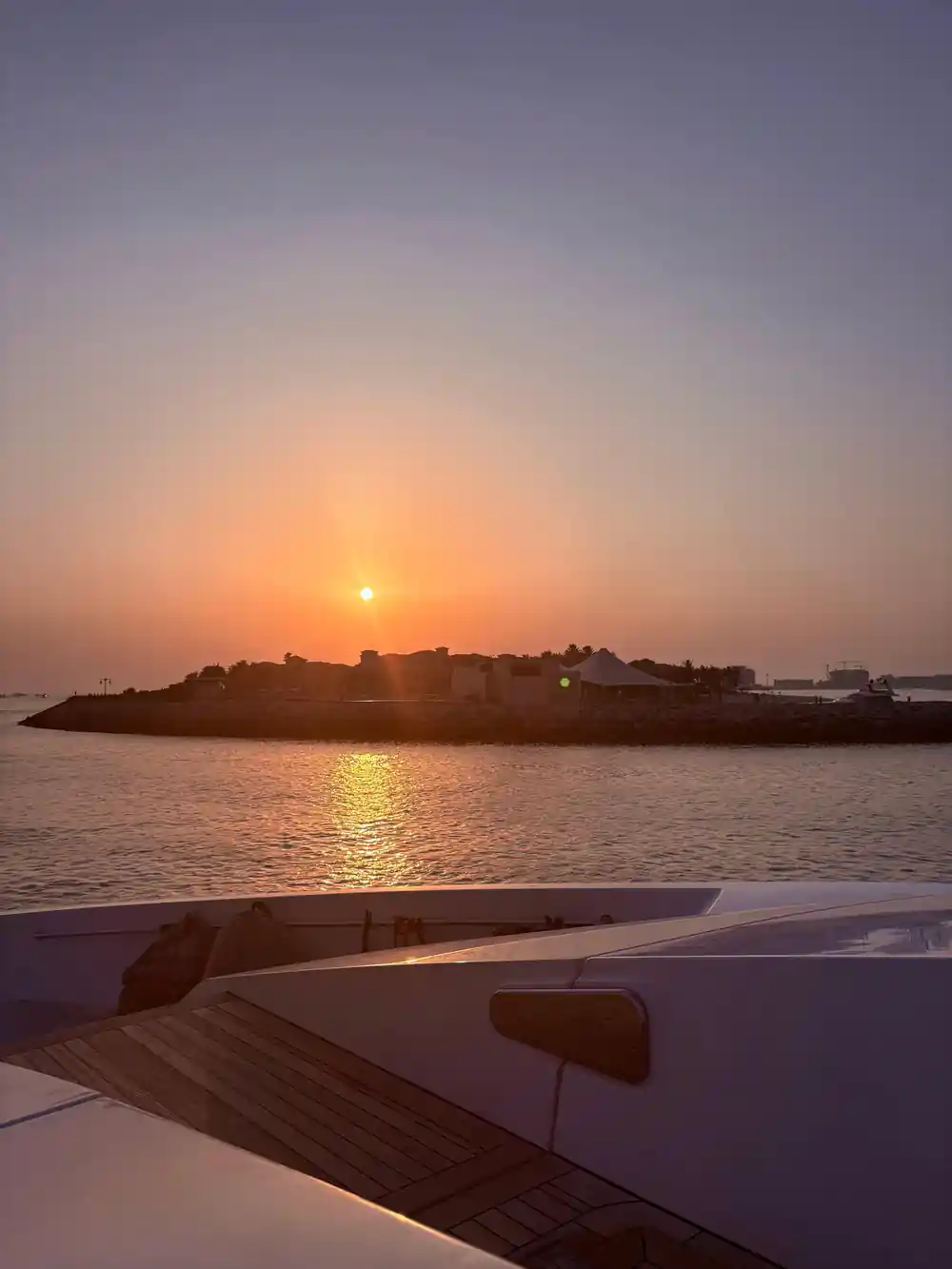 Sunset over the water from the yacht's bow