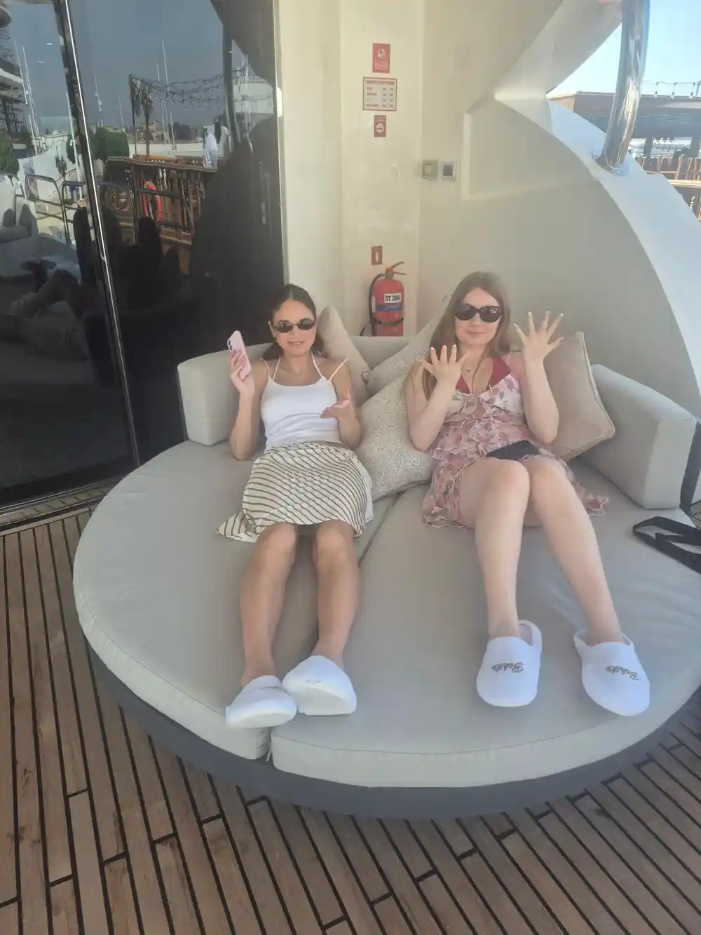 Two guests relaxing on a round deck bed