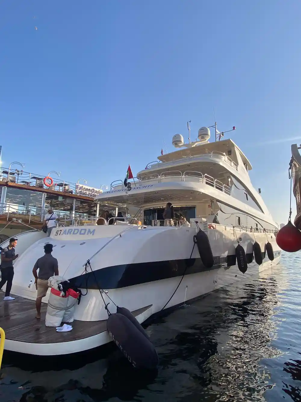 The yacht Stardom alongside with crew on the quay