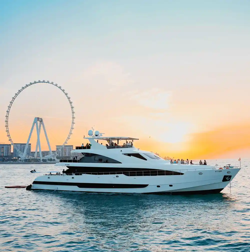 The yacht at sunset with the observation wheel behind it